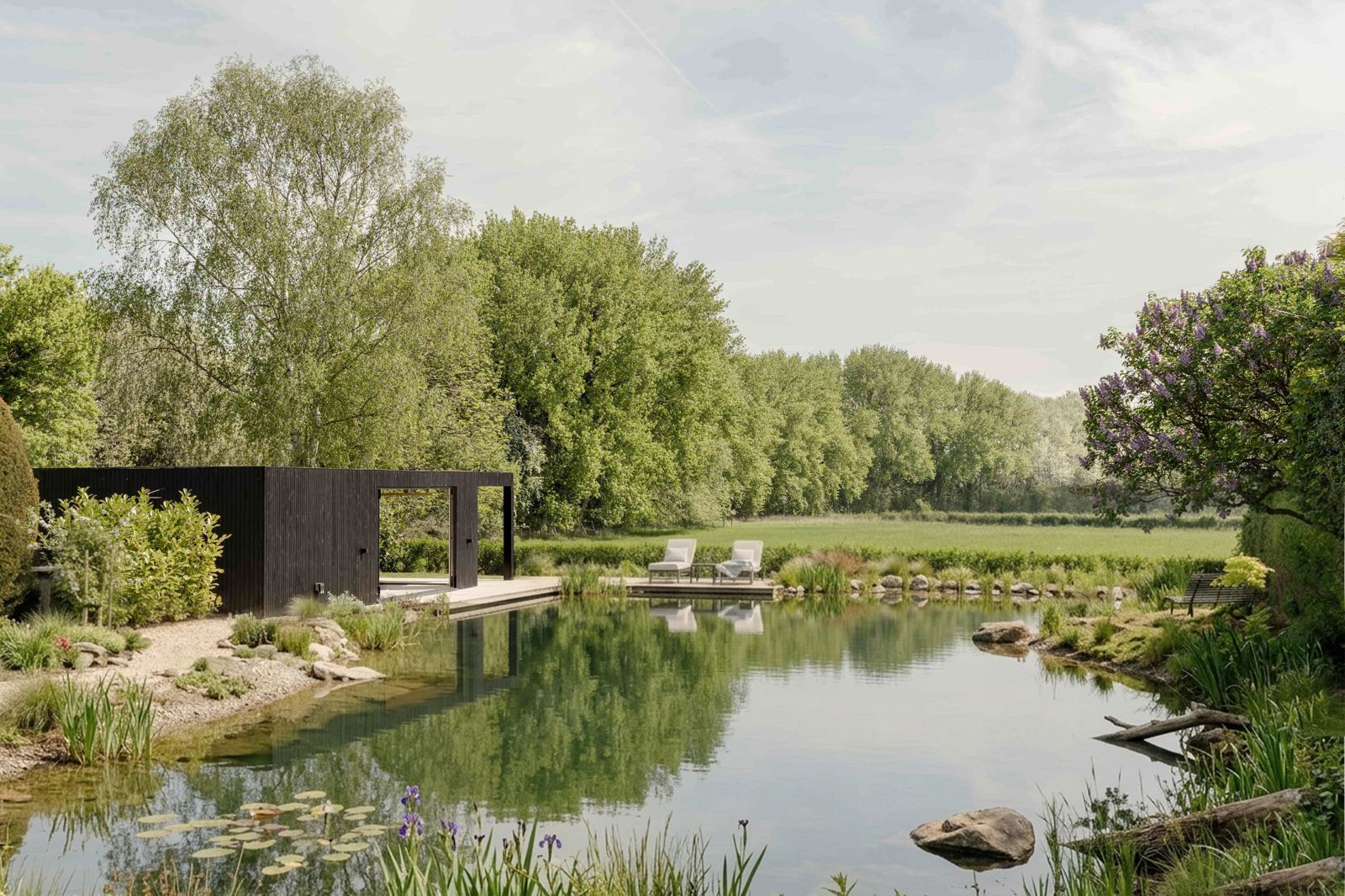 modern black cabin beside a natural swimming pond in the countryside, example of cabins for airbnb or retreat accommodation on private land