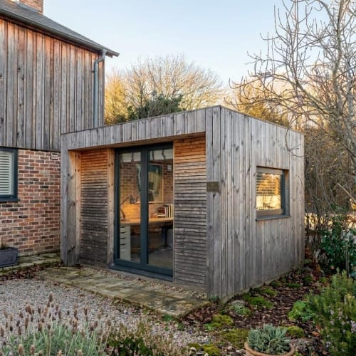 A minimalist Scandinavian garden pod featuring light natural wood siding and large glass windows for a clean, Nordic-inspired look.