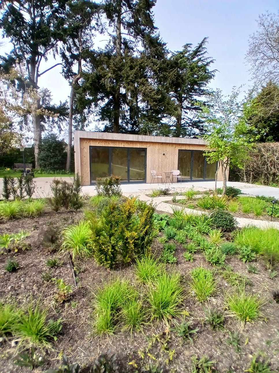 Wide external shot of a bespoke garden annexe in Cambridge, highlighting its seamless integration into a residential garden.