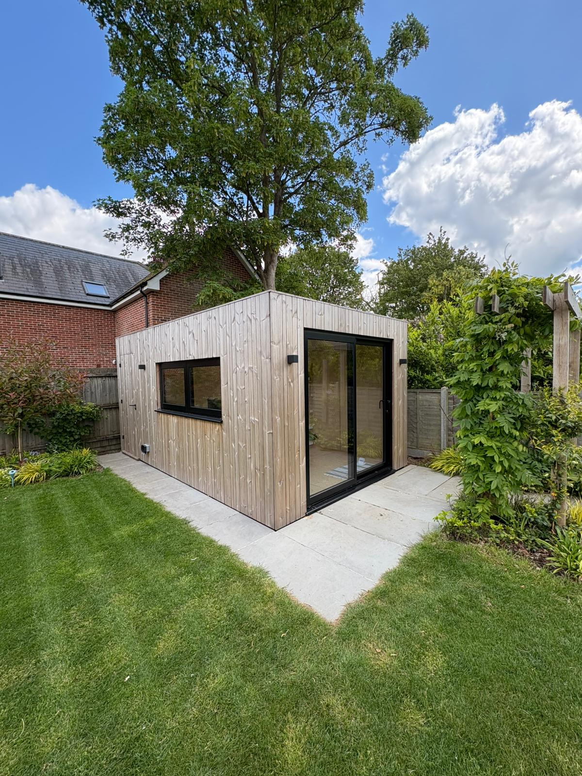 Interior layout of a multi-purpose Cambridge backyard office pod showing a dedicated desk space alongside a cozy seating area for clients or relaxation.