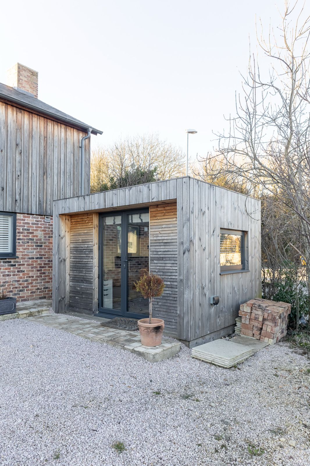 Inside a contemporary garden office pod, showcasing the clean lines of the vertical timber paneling and a modern workspace desk setup.