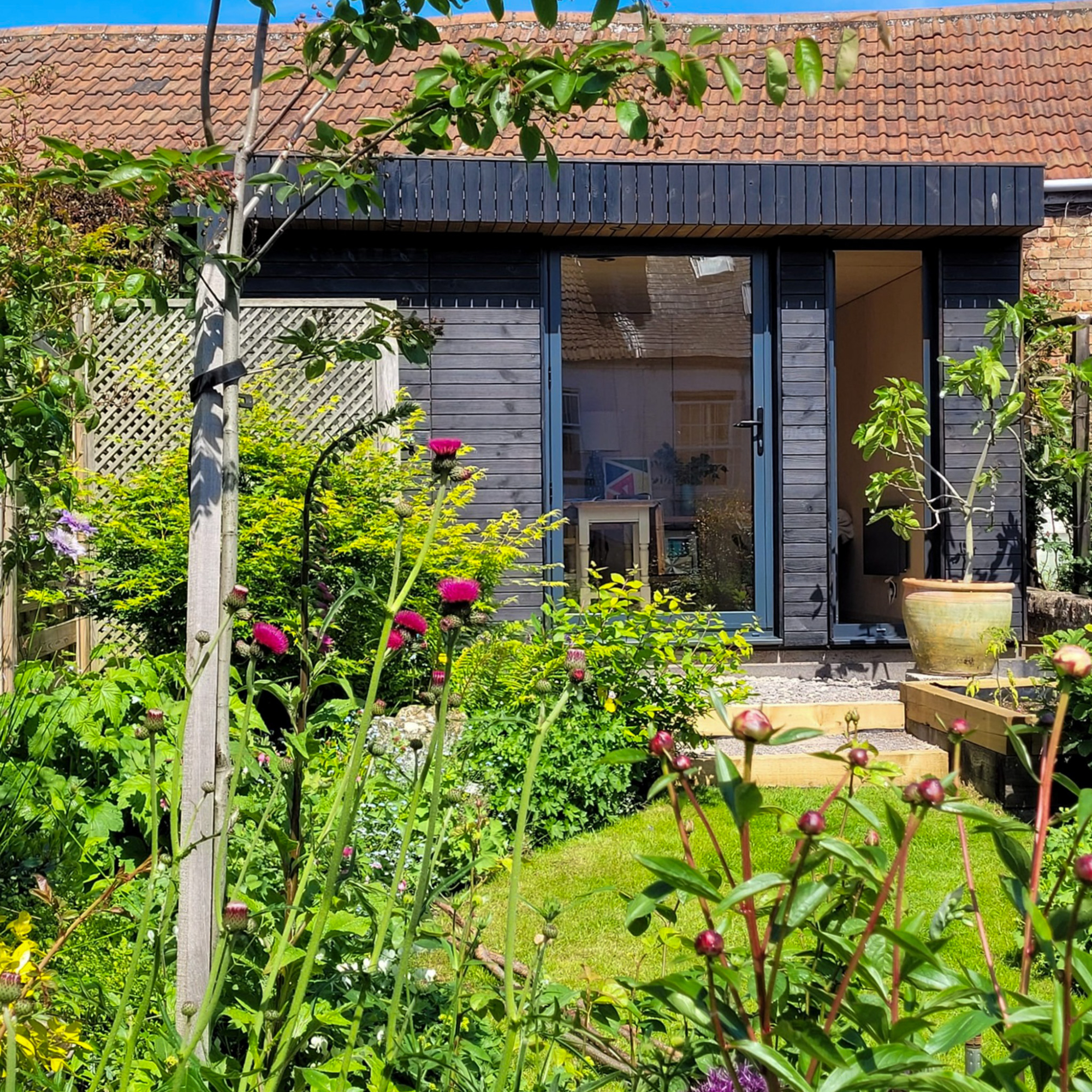 A dark, weather-resistant wood accessory structure, demonstrating an ideal layout for zoning compliance under a local Colorado backyard office permit.
