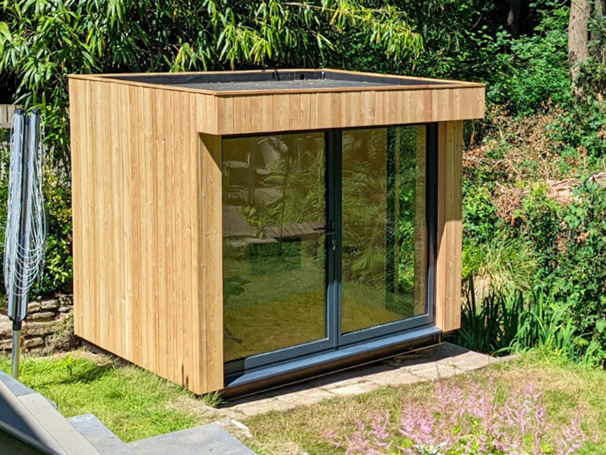 A modern, glass-fronted remote work studio built strictly within the square-footage threshold allowed by a typical residential Colorado backyard office permit.