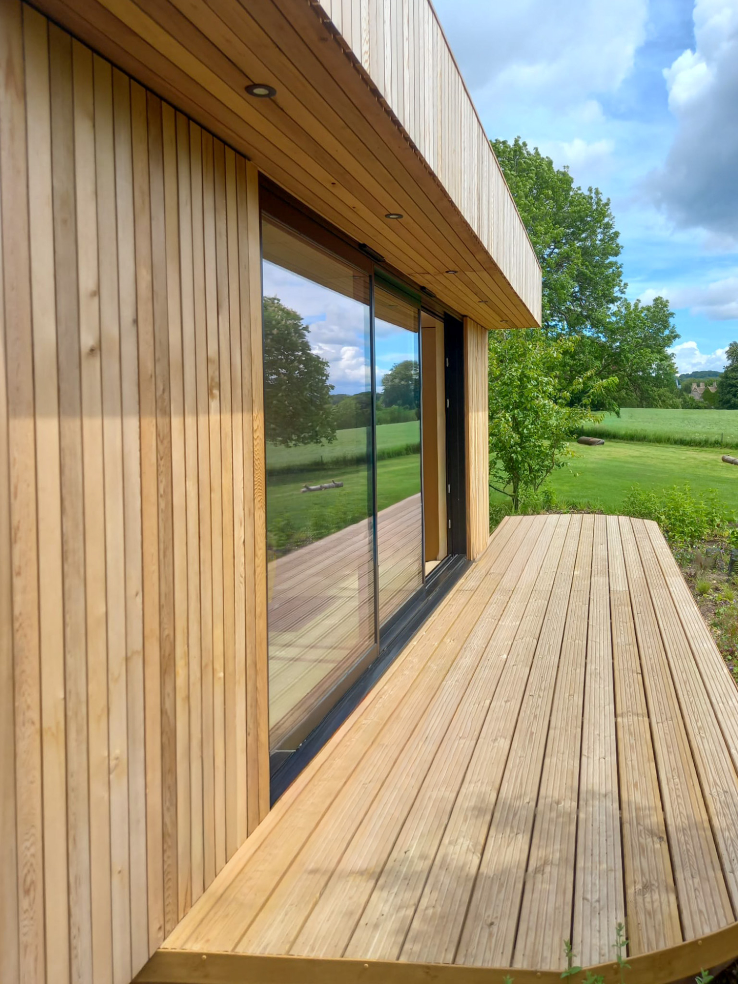 Side elevation of a fully self-contained luxury garden annex pod featuring clean rooflines and high-performance glass doors.