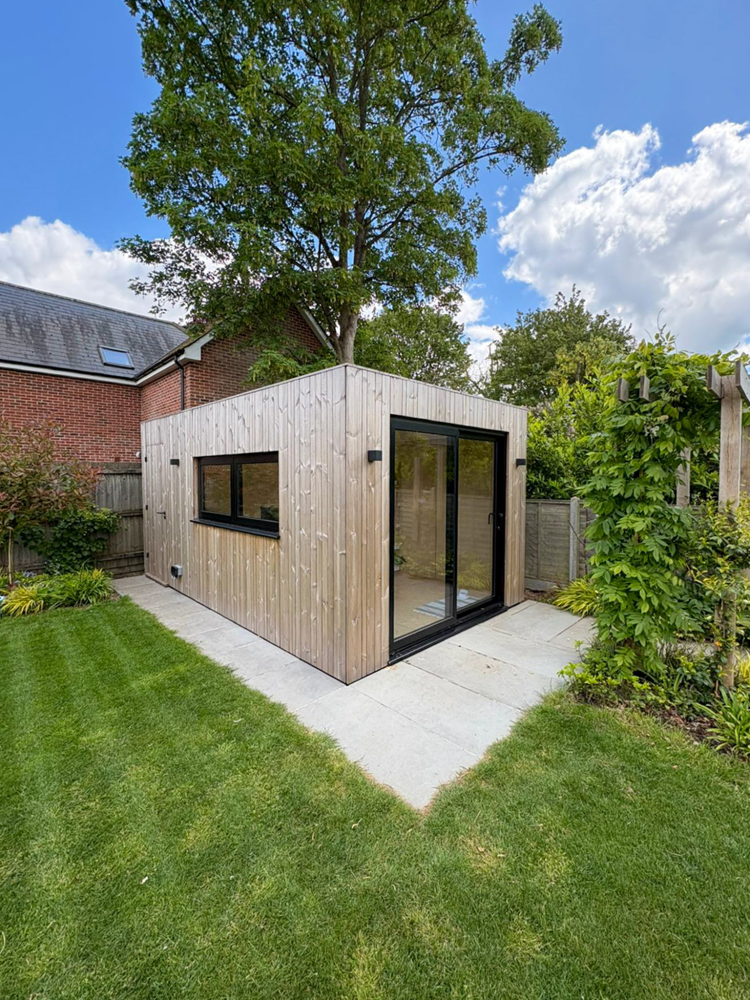 Interior layout of a multi-purpose Cambridge backyard office pod showing a dedicated desk space alongside a cozy seating area for clients or relaxation.