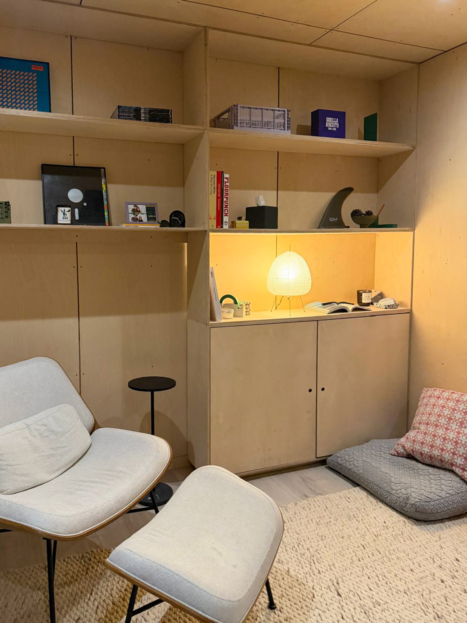 Inside the insulated OKO120 backyard office pod featuring contemporary vertical timber walls and a comfortable reading armchair.