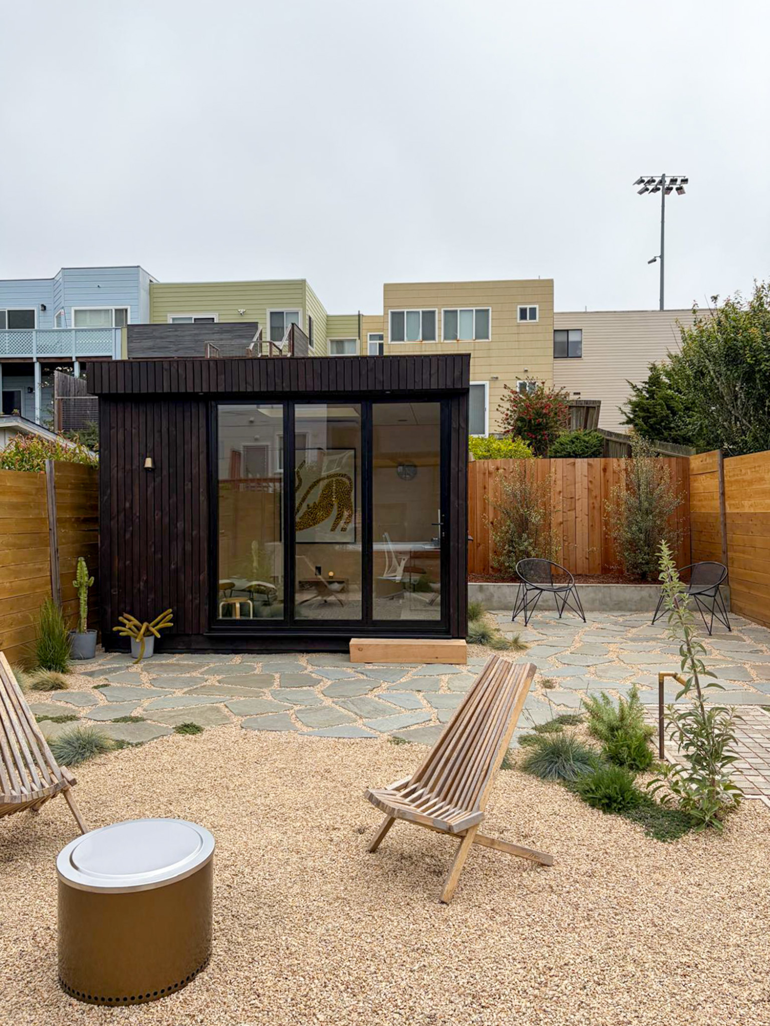 Wide external view of the OKO120 backyard office pod with open bifold doors creating a seamless indoor-outdoor connection.