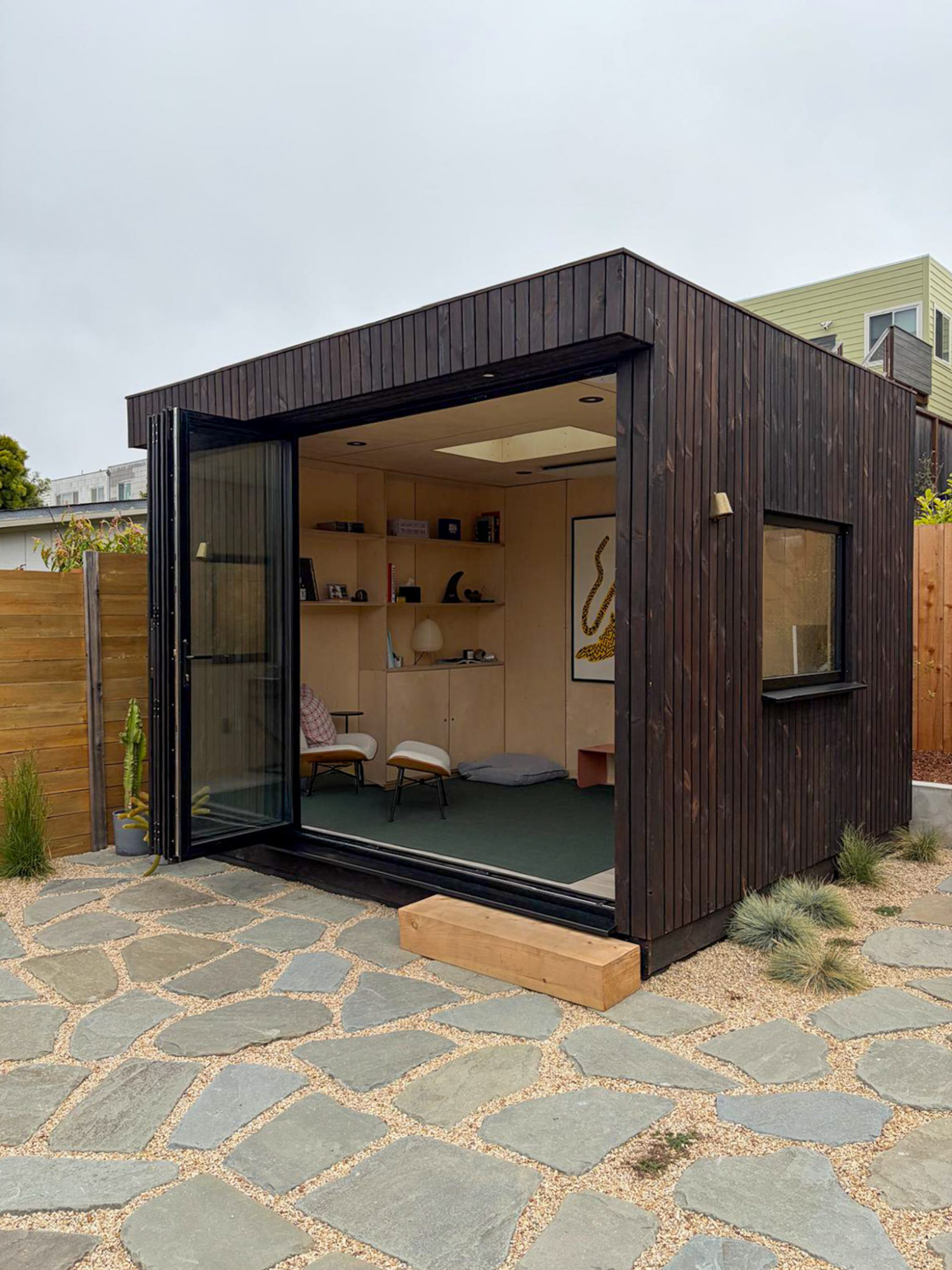 Inside the OKO120 backyard office pod, featuring a sleek workspace desk setup positioned to enjoy expansive views of the outdoor landscape.