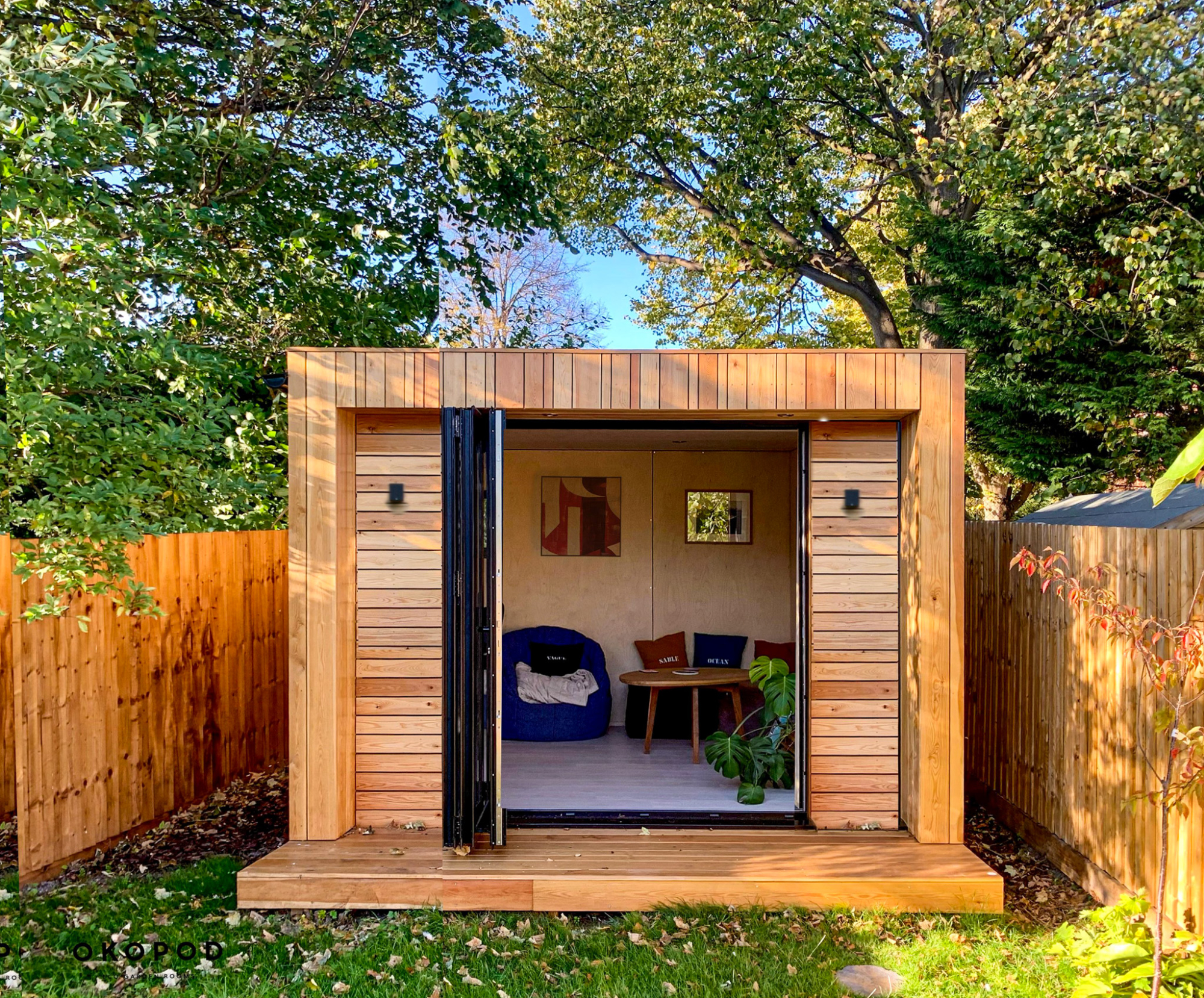 A stunning wood-clad studio with open bi-fold doors, showcasing a compact footprint optimized to bypass complex Colorado backyard office permit rules.