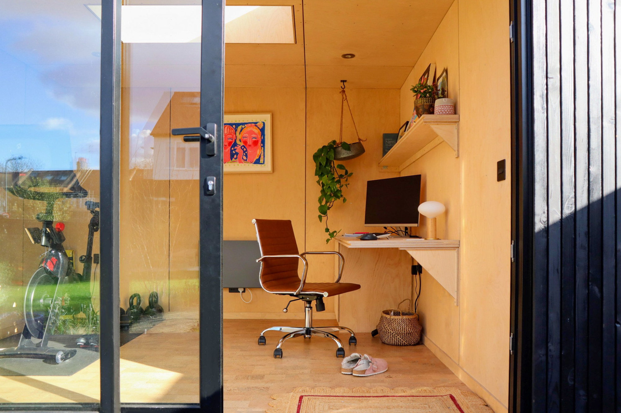 A dual-purpose office and workout room interior, maximizing the allowable footprint under a standard Colorado backyard office permit.