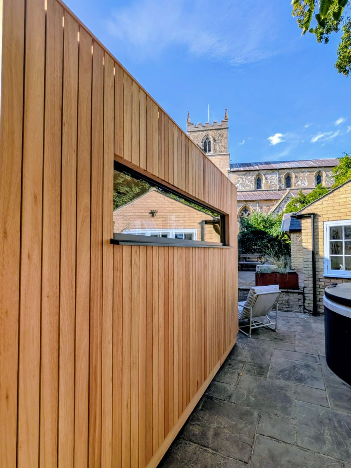 Side elevation showing vertical timber cladding and a narrow accent window on a prefabricated classroom pod.